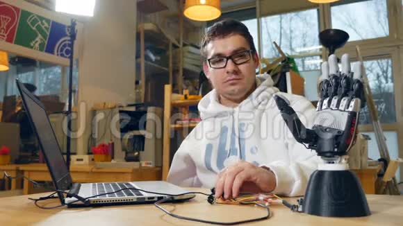 热情的年轻工程师在现代工作室工作制作三维仿生手臂视频的预览图