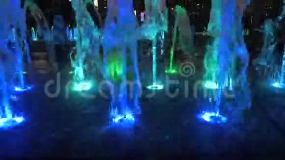 晚上在城市街道上近距离观看美丽的彩色喷泉视频的预览图