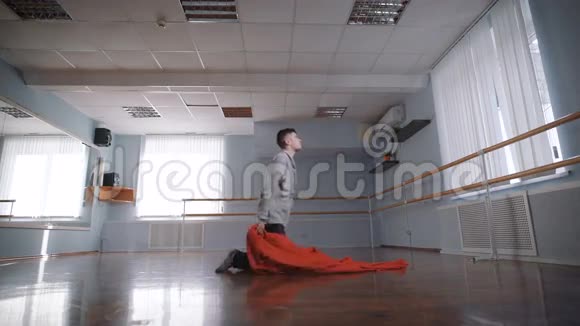 用大红布跳舞那个人摔在一块红布上美丽的运动与布舞者挥动他的红布这就是视频的预览图