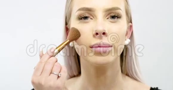 美丽的年轻女子涂干化妆品粉底视频的预览图