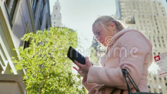 年轻的商界女性在一个大城市里使用平板电脑在城市景观的背景下摩天大楼太阳视频的预览图