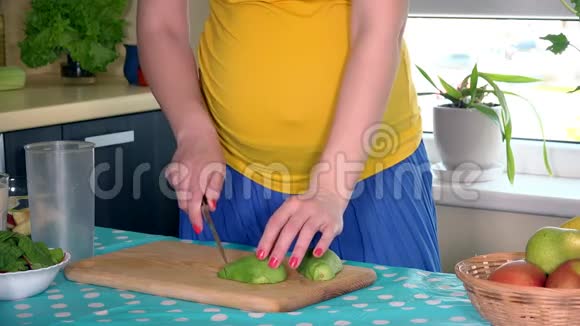 孕妇在厨房准备纯素鸡尾酒和水果视频的预览图