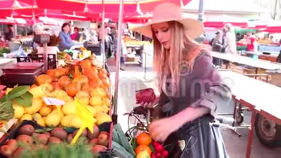 在市场上买水果的漂亮女孩视频的预览图