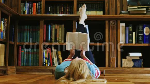 年轻女子躺着看书躺在图书馆里视频的预览图