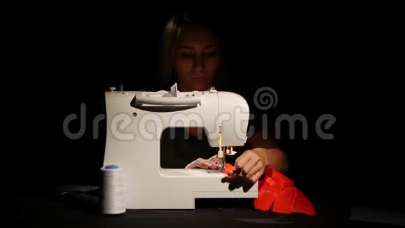 女孩缝在缝纫机上的红色布料关门视频的预览图