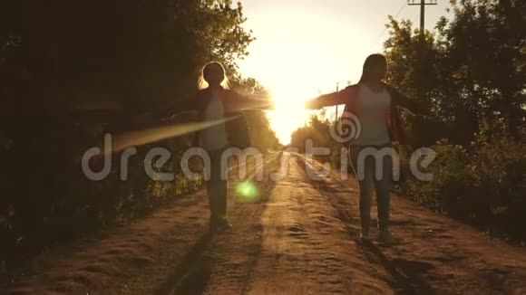 徒步旅行者女孩儿童旅行者少女旅行并牵手带背包的快乐女孩旅行者沿着乡村奔跑视频的预览图