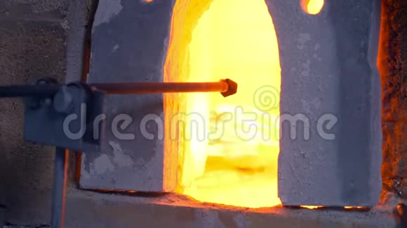吹玻璃的玻璃产品制造商男人在炉子里加热玻璃视频的预览图