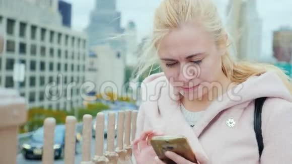 纽约一位年轻女子的肖像它应该穿在曼哈顿建筑背景上的粉红色外套打字视频的预览图