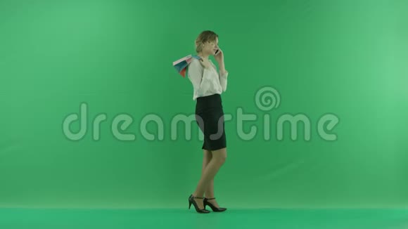 带着购物袋笑得很开心女购物者拿着购物袋侧着绿色视频的预览图