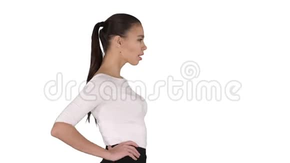 美丽的黑发女孩走路双手在白色背景上的臀部视频的预览图