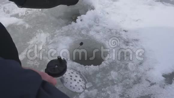 渔人在冬湖冰洞捕鱼冬天钓鱼很好视频的预览图