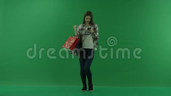 女孩站在绿色屏幕上手里拿着袋子和聊天视频的预览图