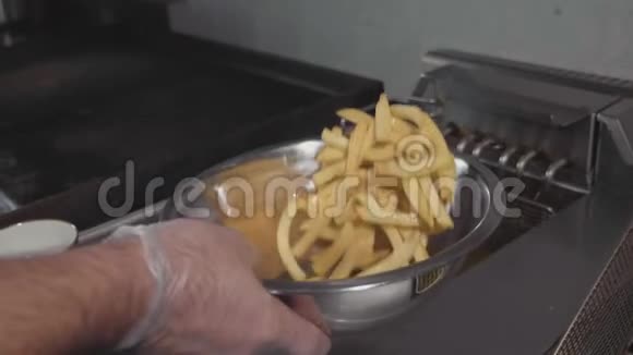 厨师混合和盐炸薯条在钢碗特写慢动作视频的预览图
