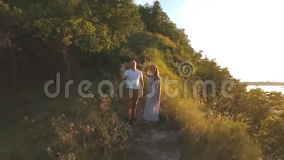 一对幸福的夫妇站在山上挥舞着他的手臂视频的预览图