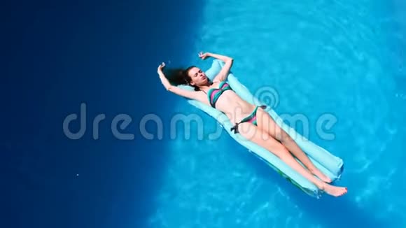 女人千禧女孩在游泳池节日酒店海滩上漂浮夏天戴着太阳镜微笑视频的预览图