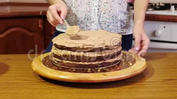 用勺子把奶油用手贴在巧克力海绵蛋糕上视频的预览图