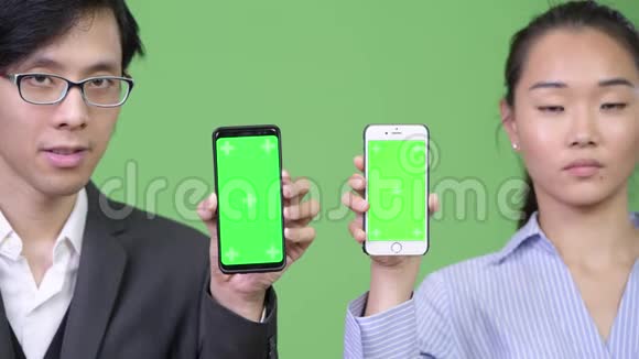 年轻的亚洲商业情侣一起玩电话视频的预览图