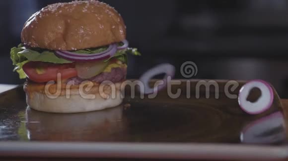 新鲜洋葱圈掉在汉堡包上慢动作垃圾食品概念视频的预览图