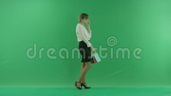 带着购物袋笑得很开心女购物者拿着购物袋侧着绿色视频的预览图