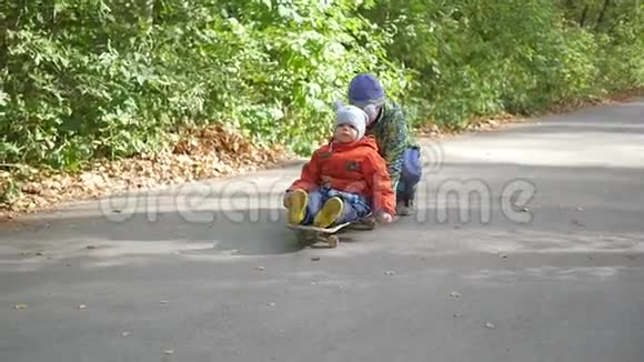 两个孩子在公园里坐在滑板上玩得最开心视频的预览图