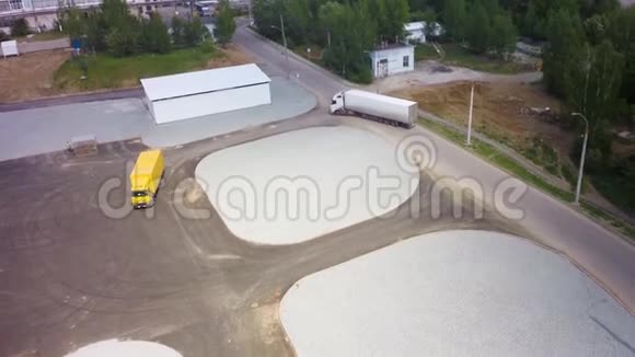 停在工业大楼前的卡车的鸟瞰图剪辑空中飞行带有货物的白色半车的高空俯视图视频的预览图