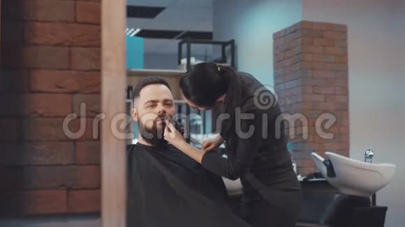 女理发师的样子剪男客户的胡子视频的预览图