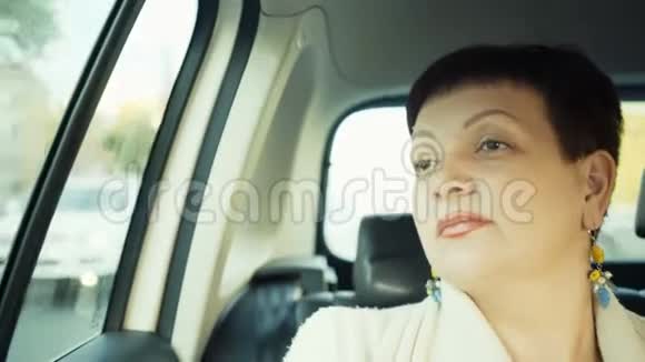 阳光明媚的日子里女人坐着车穿过城市视频的预览图
