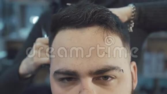 在理发店剪雄性头发的女理发师视频的预览图