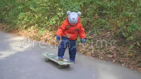 一个小孩子在公园里学滑板视频的预览图