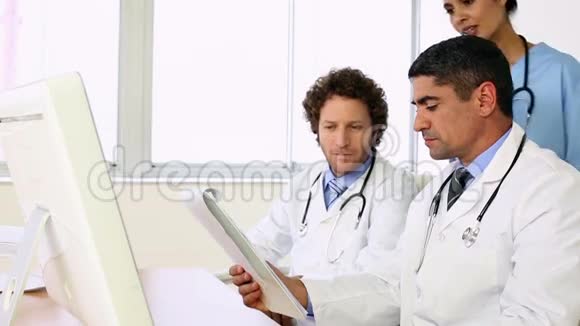 坐在办公桌前的医生和护士谈论xray视频的预览图
