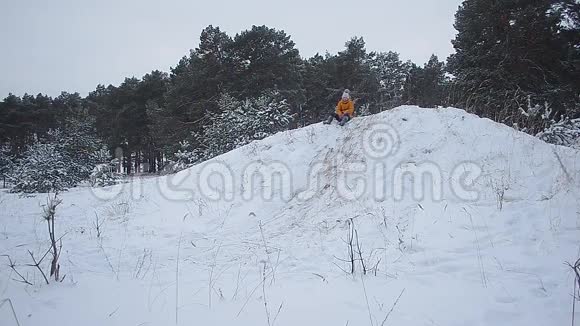 快乐的微笑女孩在冬天带着雪卷绕山一家人在白雪覆盖的冬季公园里散步视频的预览图