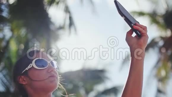 美丽的深色太阳镜自拍与手机下的棕榈树假期1920x1080视频的预览图