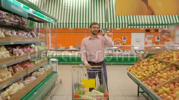 食品市场上的男人用手机说话视频的预览图