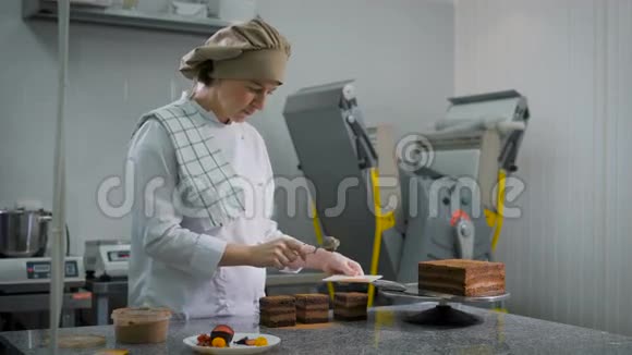 女孩糕点厨师穿着白色西装和棕色帽子带着严肃的表情巧克力蛋糕这些都是视频的预览图