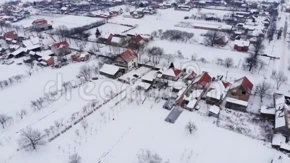 在白雪公主和灰蒙蒙的冬季天气下乡村的空中镜头视频的预览图