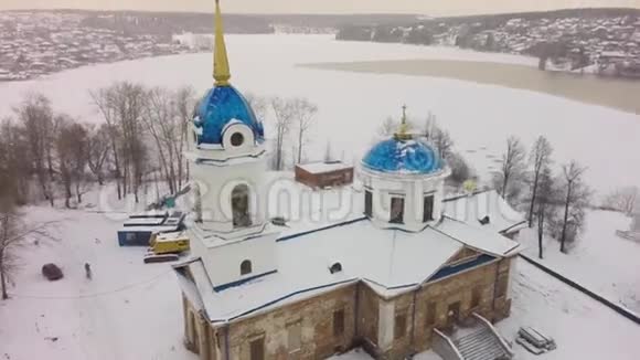 冬季大雪时在白色教堂上空鸟瞰俄罗斯教堂的空中景观剪辑小镇教堂视频的预览图