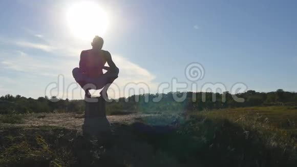 运动员在山上做倒立年轻男子站在瑜伽姿势的自然他练习瑜伽动作和姿势视频的预览图