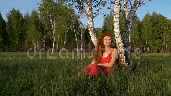 唱歌的女人坐在树旁视频的预览图