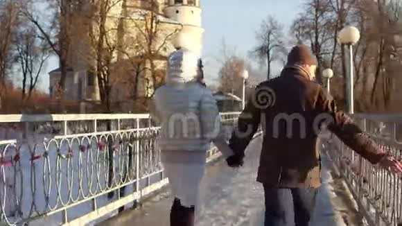 男人和女人牵着手走在一座充满爱锁的小桥上4科斯特德姆后景视频的预览图