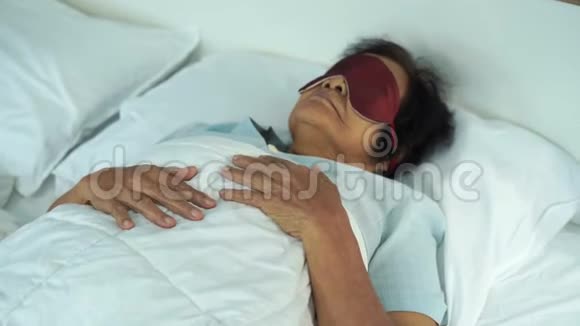 戴眼罩的老年妇女睡在床上视频的预览图