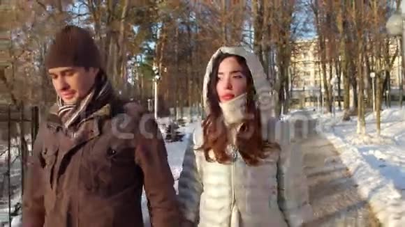 漂亮体贴的男人和女人在冬天的公园里牵手4K稳定射击视频的预览图