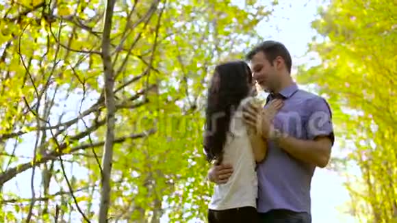 秋日公园里的一对幸福的年轻情侣互相看着视频的预览图