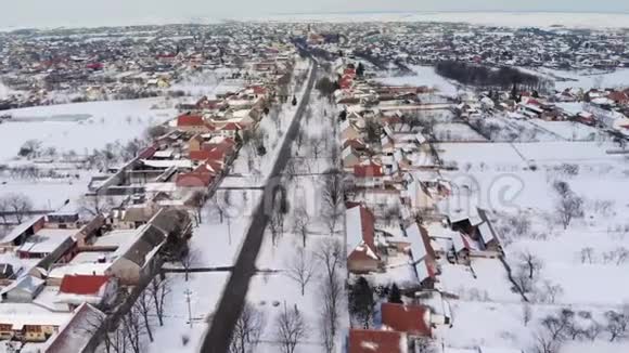 在白雪公主和灰蒙蒙的冬季天气下乡村的空中镜头视频的预览图