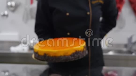 一个糖果师把一个新鲜的橘子蛋糕放在桌子上视频的预览图