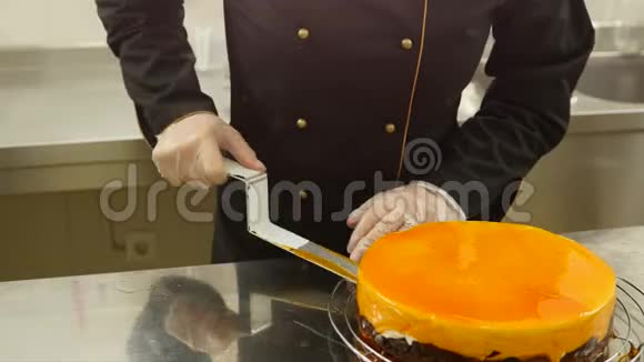 一个糖果师用巧克力片装饰一个橙色蛋糕的边缘视频的预览图