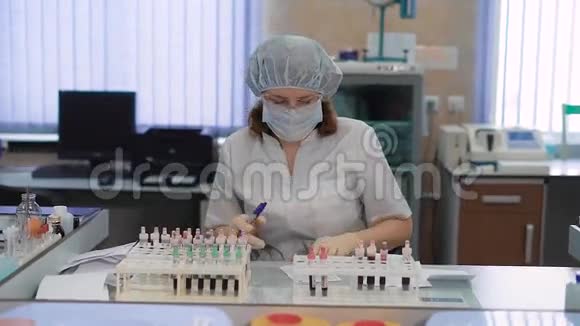 化验人员正在分析和更换血液试管在医院的医学实验室工作视频的预览图
