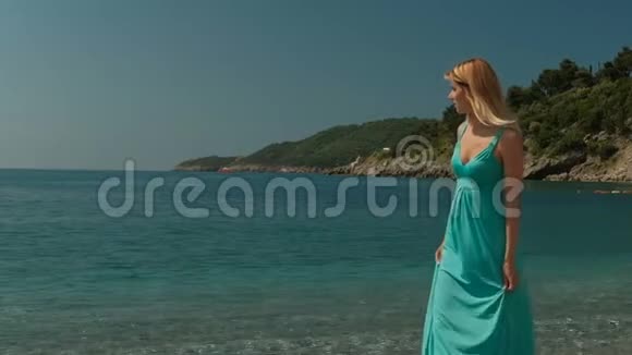 阳光明媚的一天迷人的女人在海边漫步视频的预览图