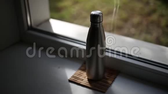 窗户背景上的水用钢制热瓶视频的预览图