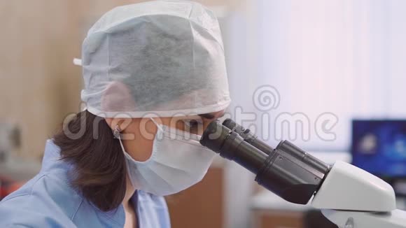 女医务人员带着显微镜在实验室她正在研究血液测试或生物涂片是的视频的预览图