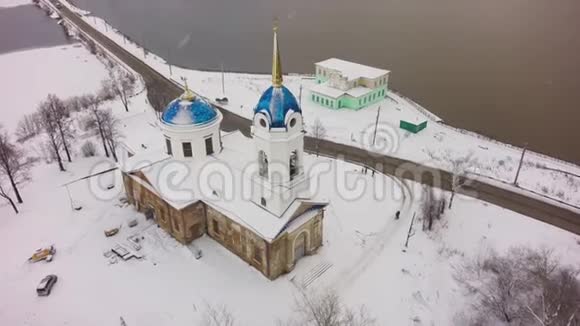 冬季大雪时在白色教堂上空鸟瞰俄罗斯教堂的空中景观剪辑小镇教堂视频的预览图